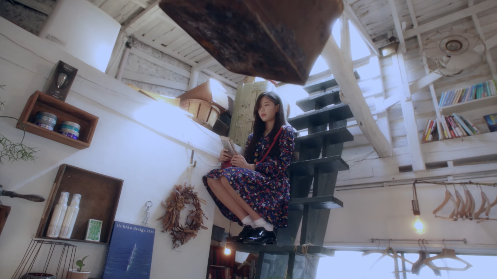 Hyunjin sitting on a ladder.